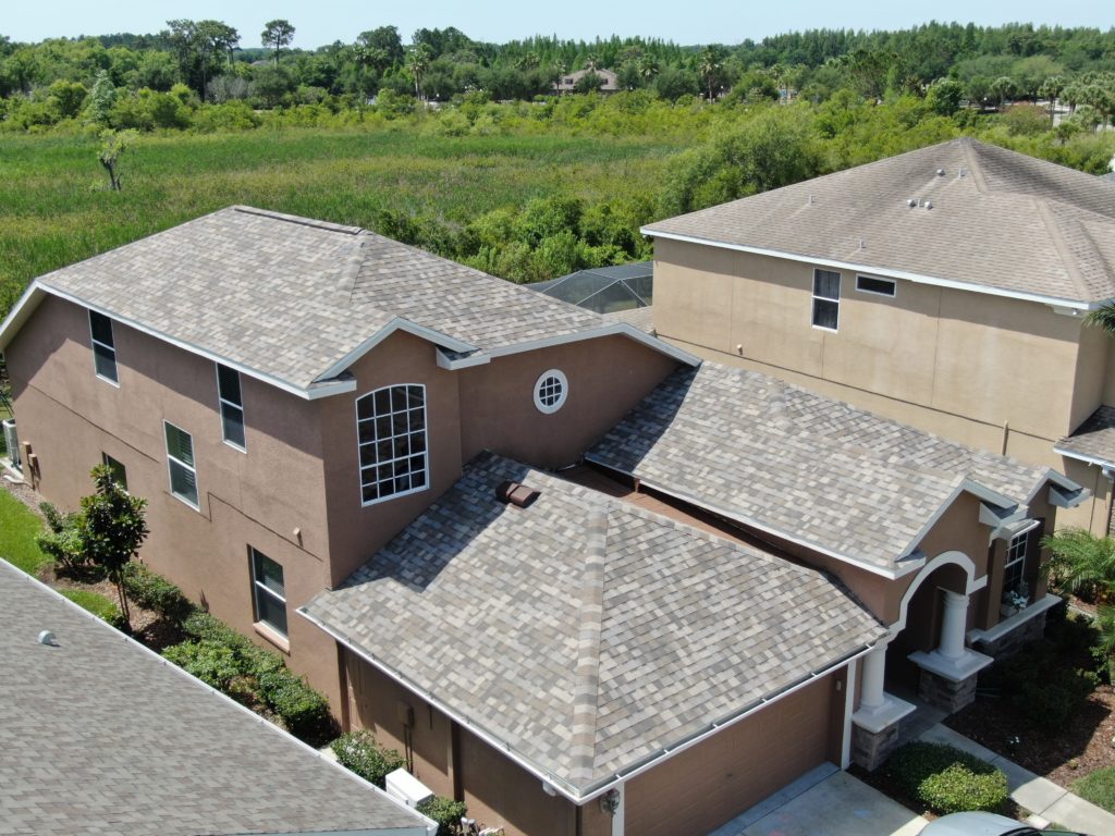 new shingle roof on a house next to a house with an old roof