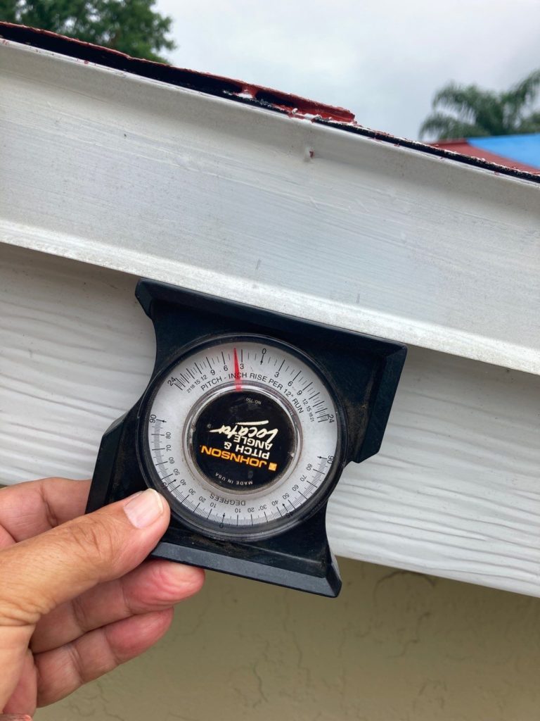 roofer measuring the pitch of a roof