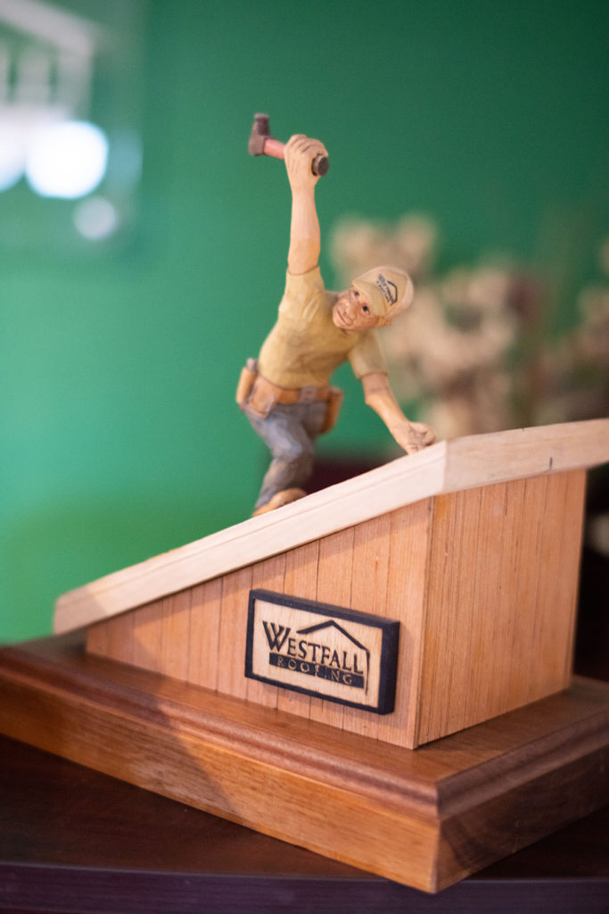 Westfall Roofing award with a figure of a roofer