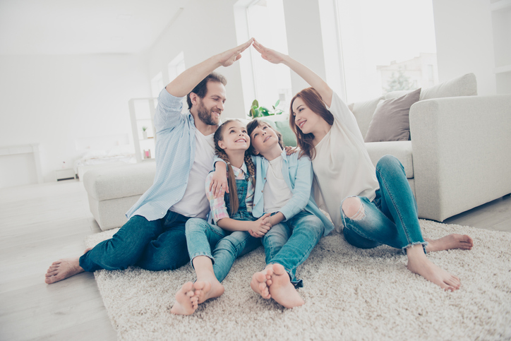 family with the parents making a roof figure with hands and arms over heads