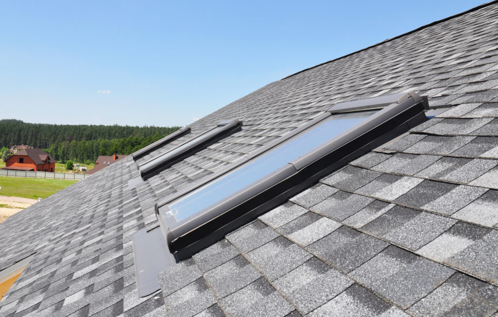 three new skylights on a gray asphalt shingle roof.