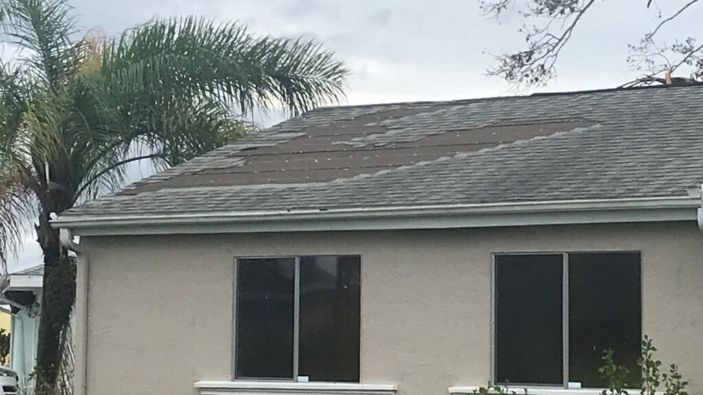 Residential asphalt shingle roof in Sarasota with storm damage.