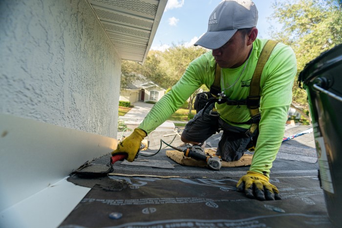 Westfall Roofing roofing contractor sealing seams on residential roof replacement in Sarasota