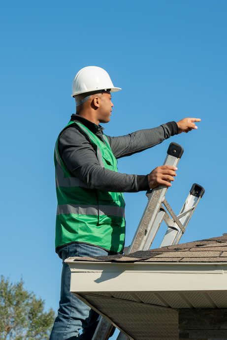 A Westfall Roofing professional prioritizing safety, wearing a hard hat and high-visibility vest while inspecting a roof. The worker carefully follows safety protocols, ensuring a secure and hazard-free roofing project.